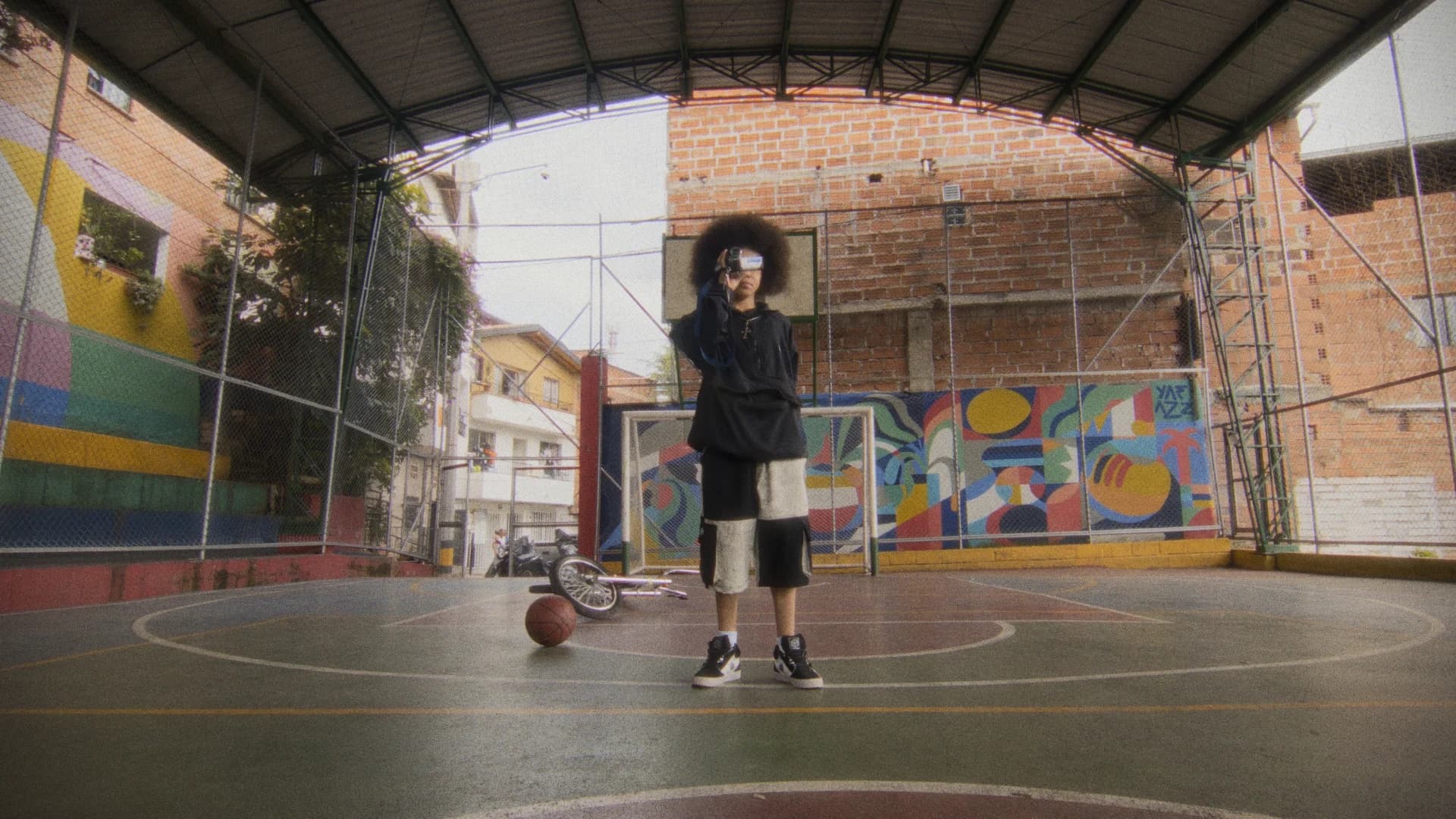 Artista con una cámara pequeña en una cancha