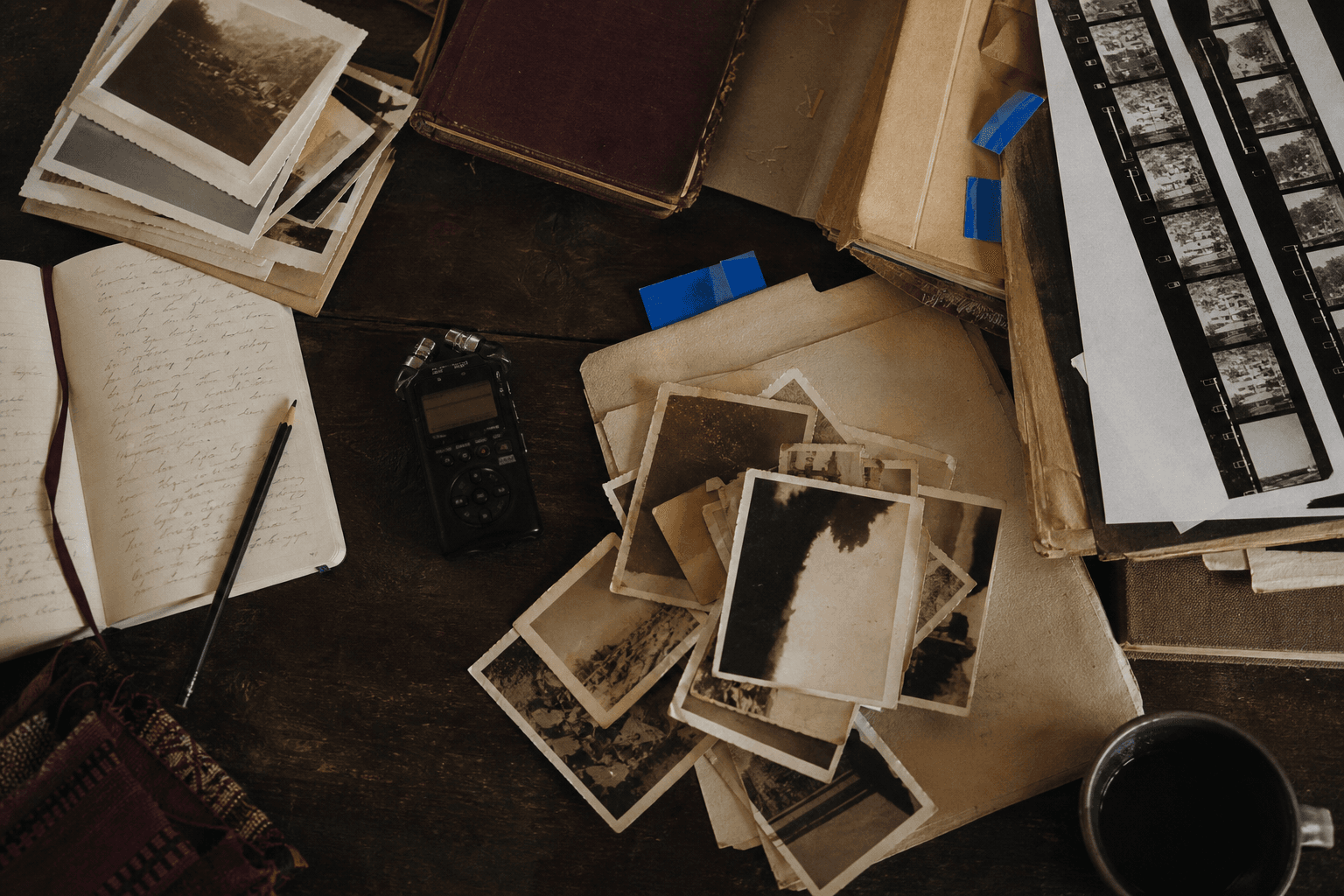 Archive table with photographs, interview notes and an audio recorder