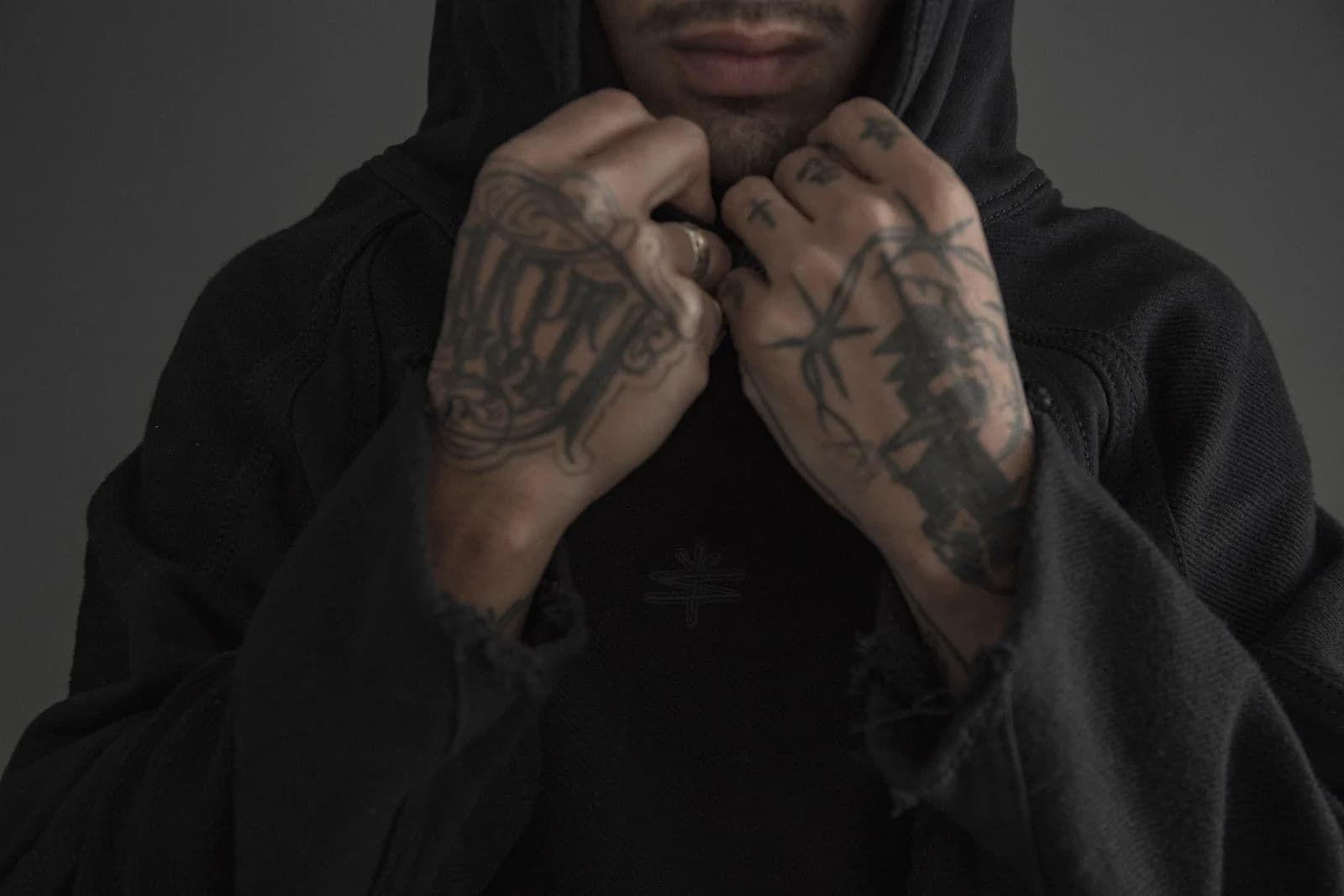 SIN NOMBRE Sombra archive photography: a black garment and the embroidered brand symbol